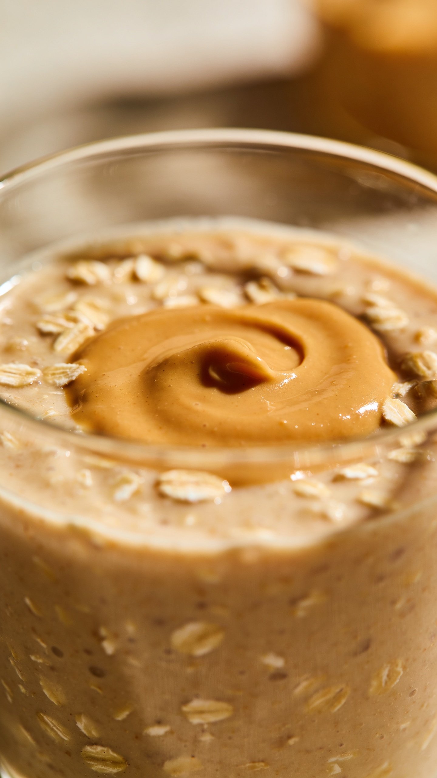 closeup of peanut butter oat breakfast smoothie in clear glass