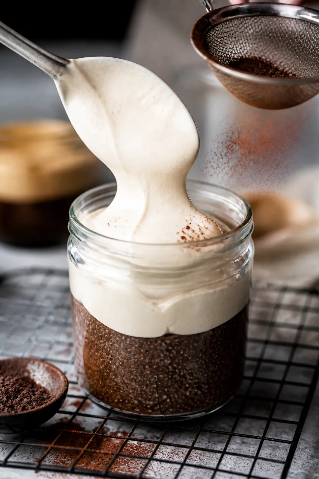 Close-up detail: A glass jar mid-prep showing the coffee-infused chia layer just set and glossy, bei