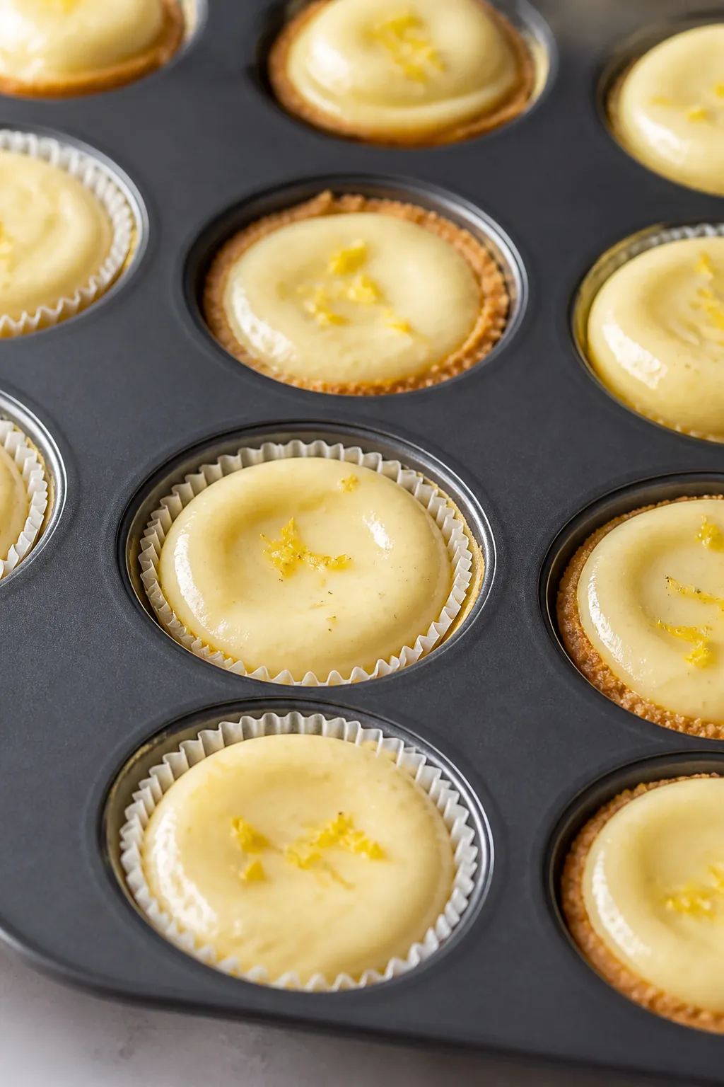 Close-up detail: A just-baked tray of mini high-protein low-carb cheesecake bites in a mini muffin t