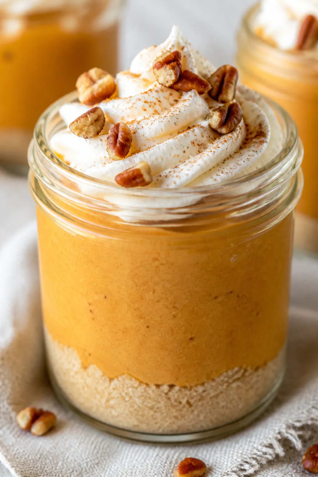 Close-up detail: A no-bake pumpkin cheesecake jar just after chilling, creamy, silky pumpkin filling
