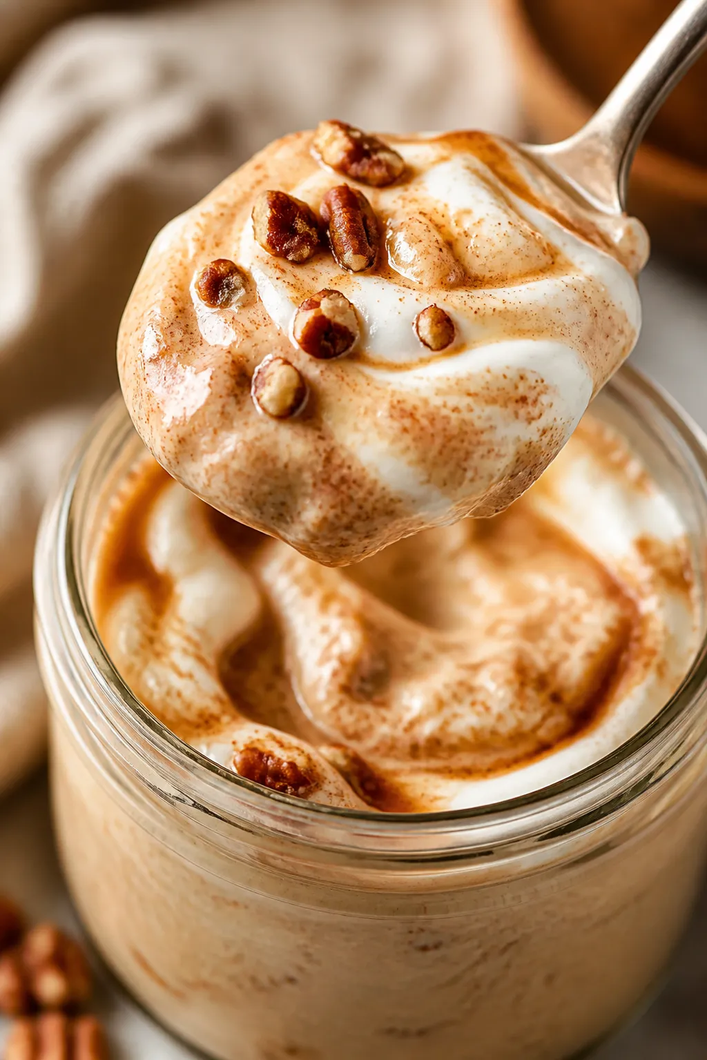 Close-up detail: A spoonful of Greek Yogurt Cinnamon Roll Protein Pudding lifted from a chilled glas