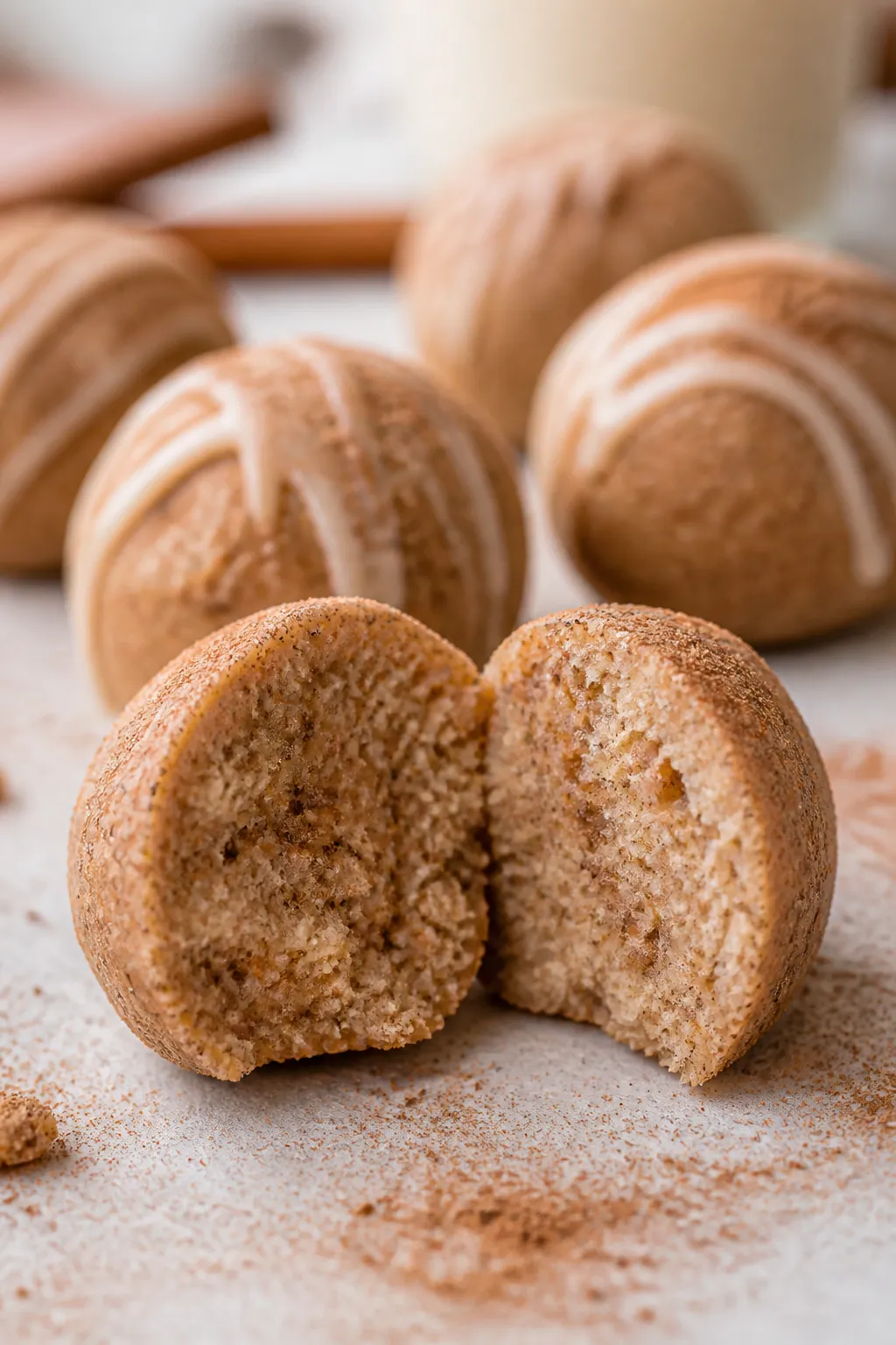 Close-up detail shot: A just-finished cinnamon roll protein bite sliced in half to reveal its soft, 