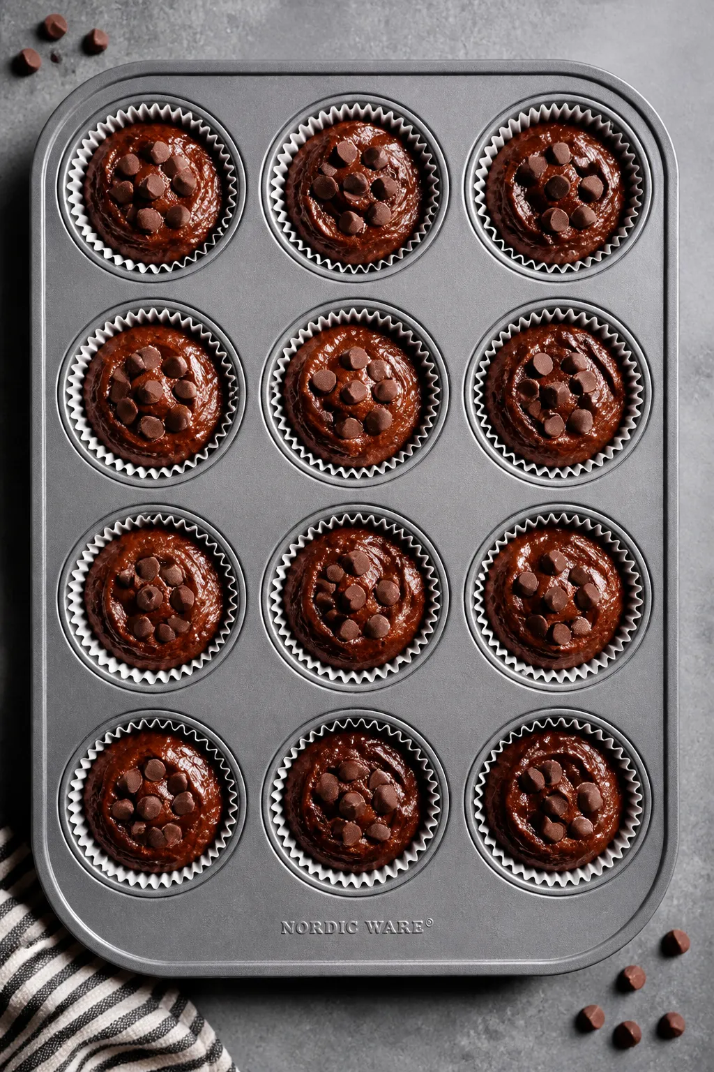 Cooking process: Overhead shot of a 12-cup muffin tin just filled 3/4 full with thick, scoopable cho
