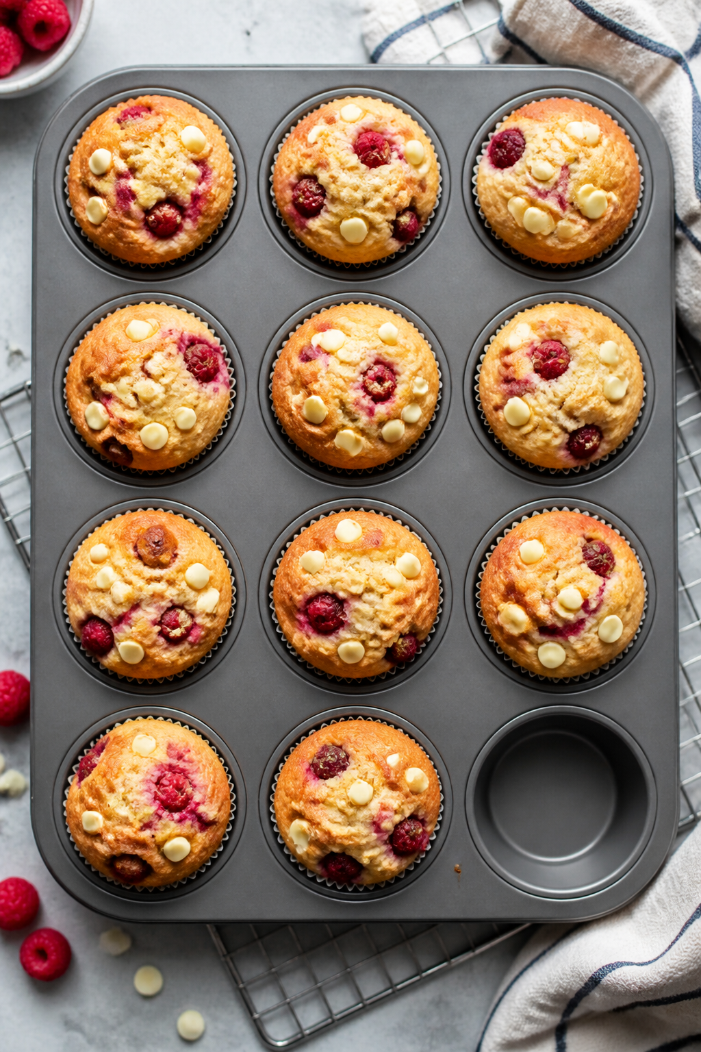 Cooking process: Overhead shot of a 12-cup muffin pan fresh from the oven, each liner filled with go