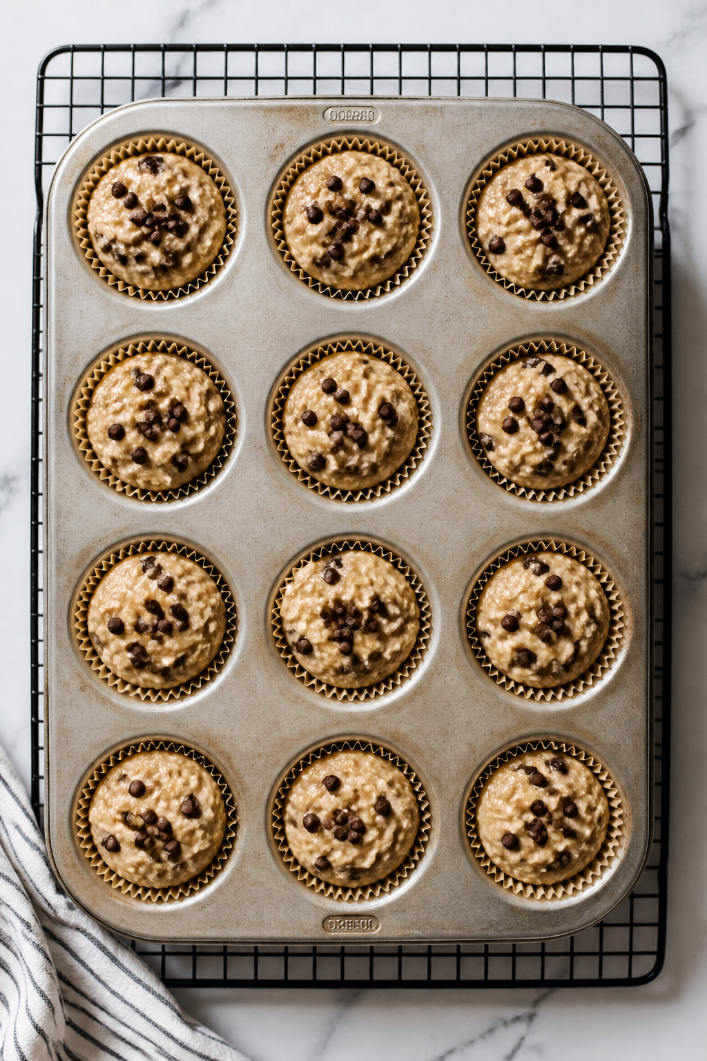 Cooking process: Overhead shot of a muffin tin filled 3/4 full with the thick, scoopable batter afte