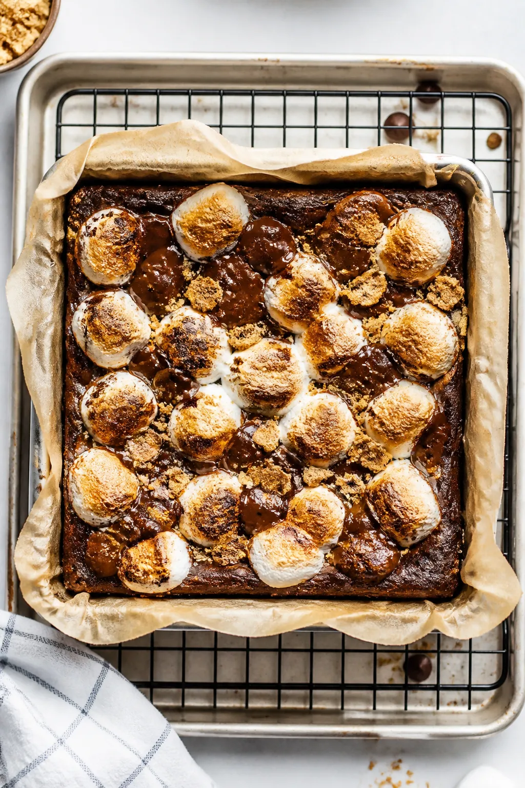 Cooking process: Overhead shot of an 8x8 pan of freshly baked protein brownies on parchment, immedia