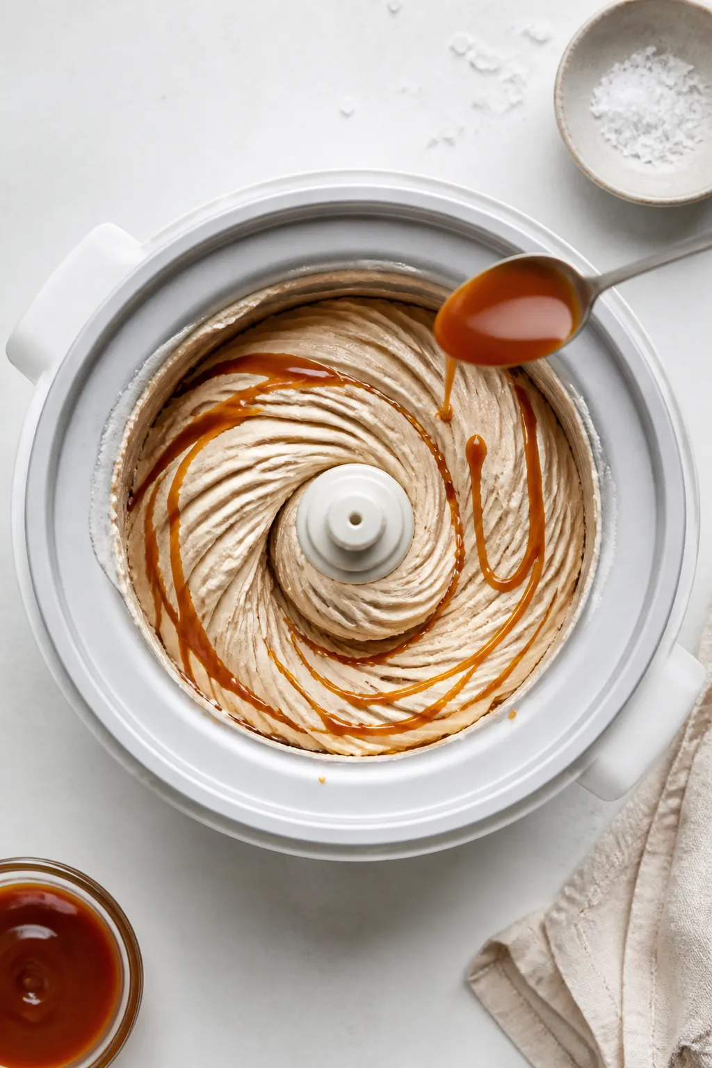 Cooking process: Overhead shot of the ice cream base at soft-serve stage inside an ice cream maker b