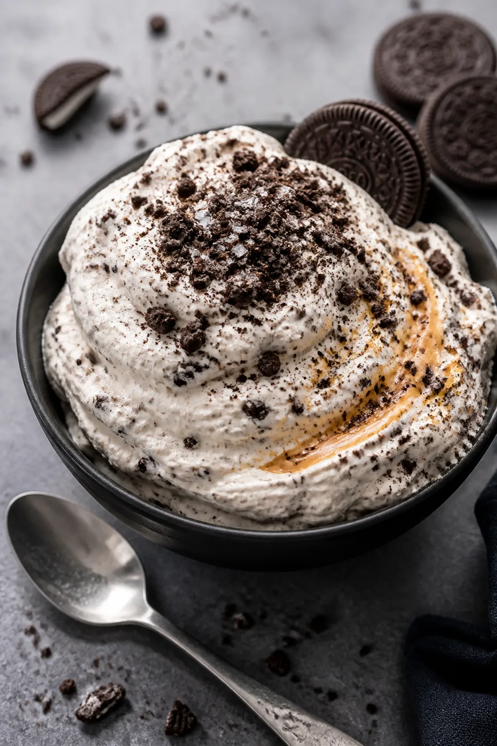 Final dish presentation: Beautifully plated Oreo protein fluff in a matte black dessert bowl, piled 