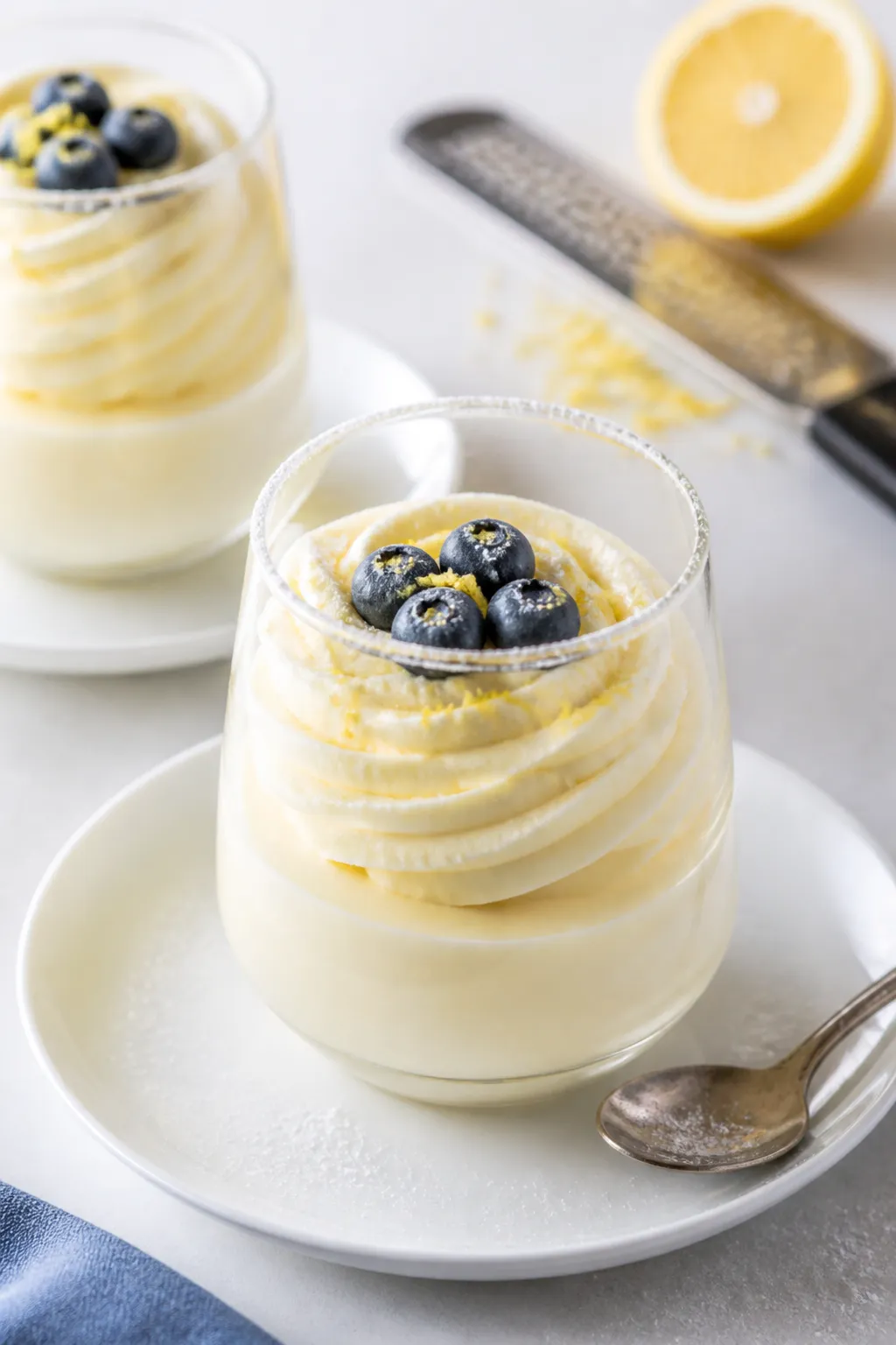 Final dish presentation: Elegant lemon cheesecake mousse piped into stemless dessert glasses, topped