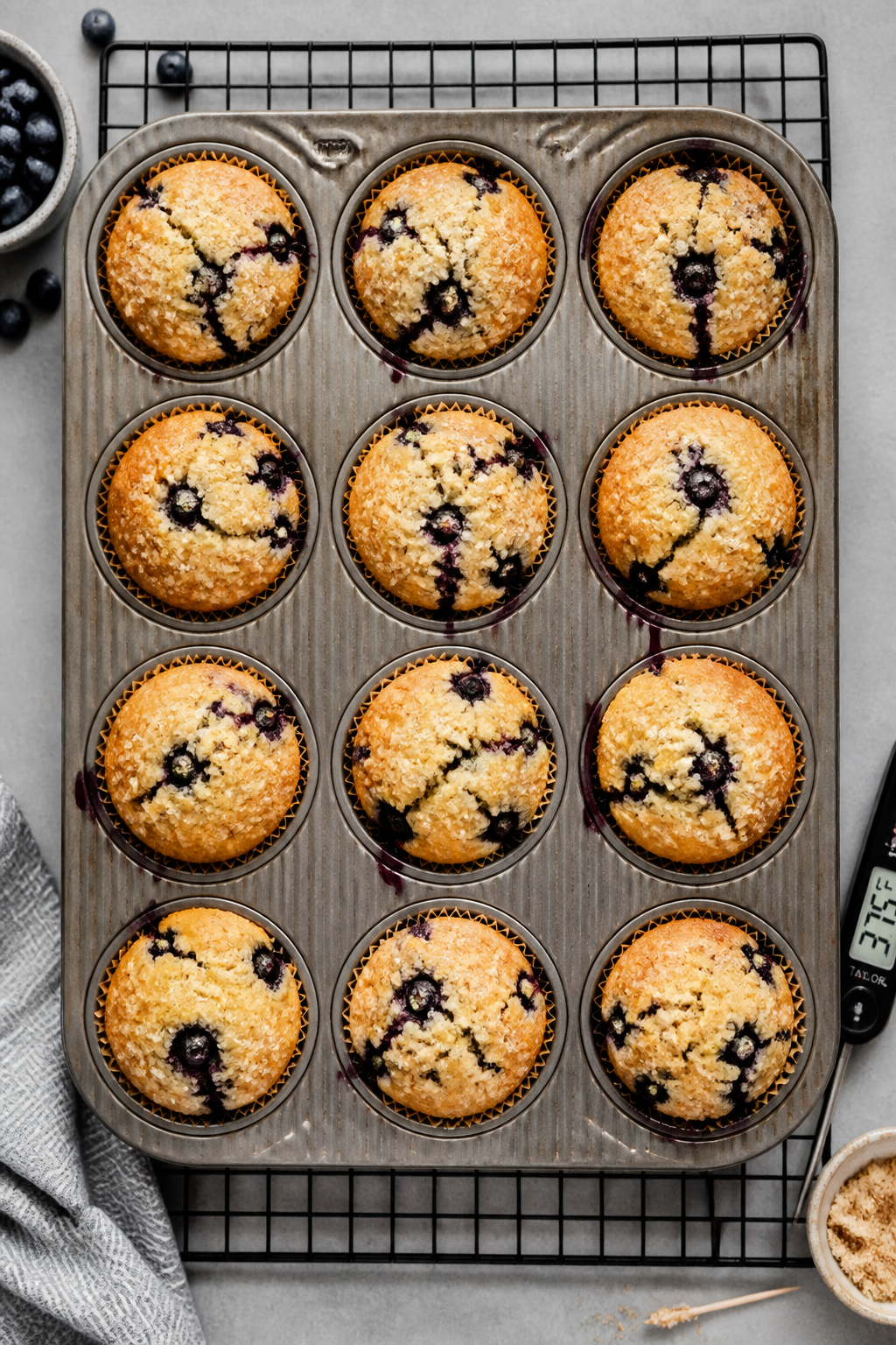 Tasty top view: Overhead shot of a 12-cup muffin tin just out of the oven on a cooling rack—muffin