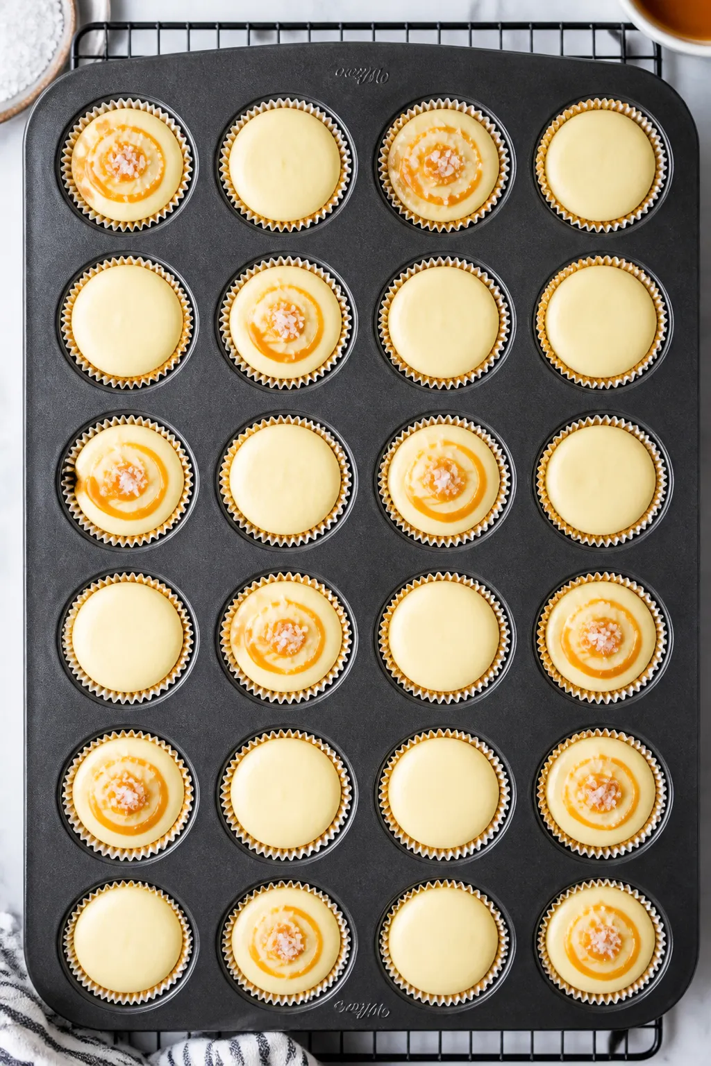 Tasty top view: Overhead shot of a 24-cup mini muffin pan lined with papers, each well filled with b