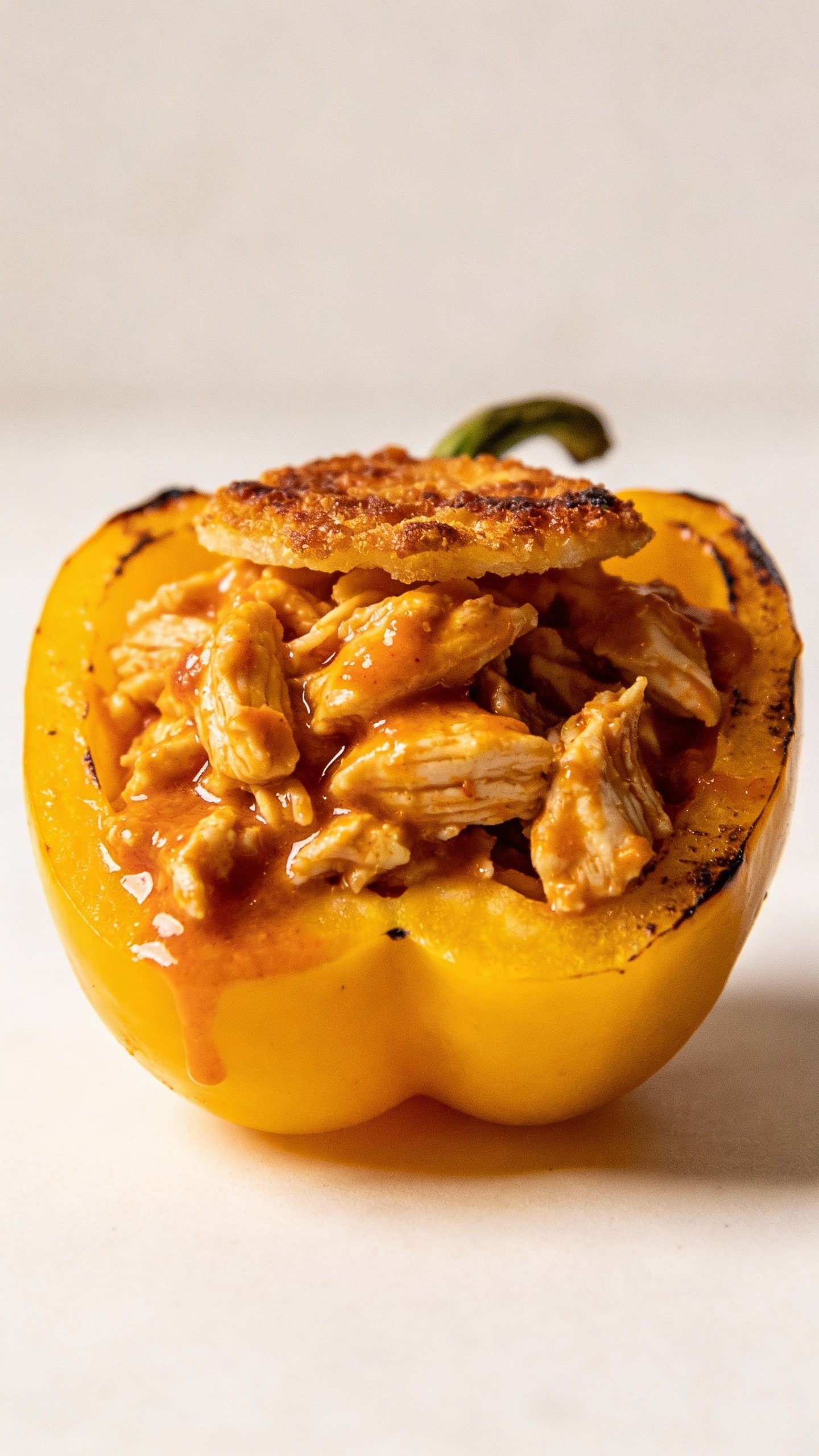single halved yellow bell pepper filled with buffalo chicken, broiled