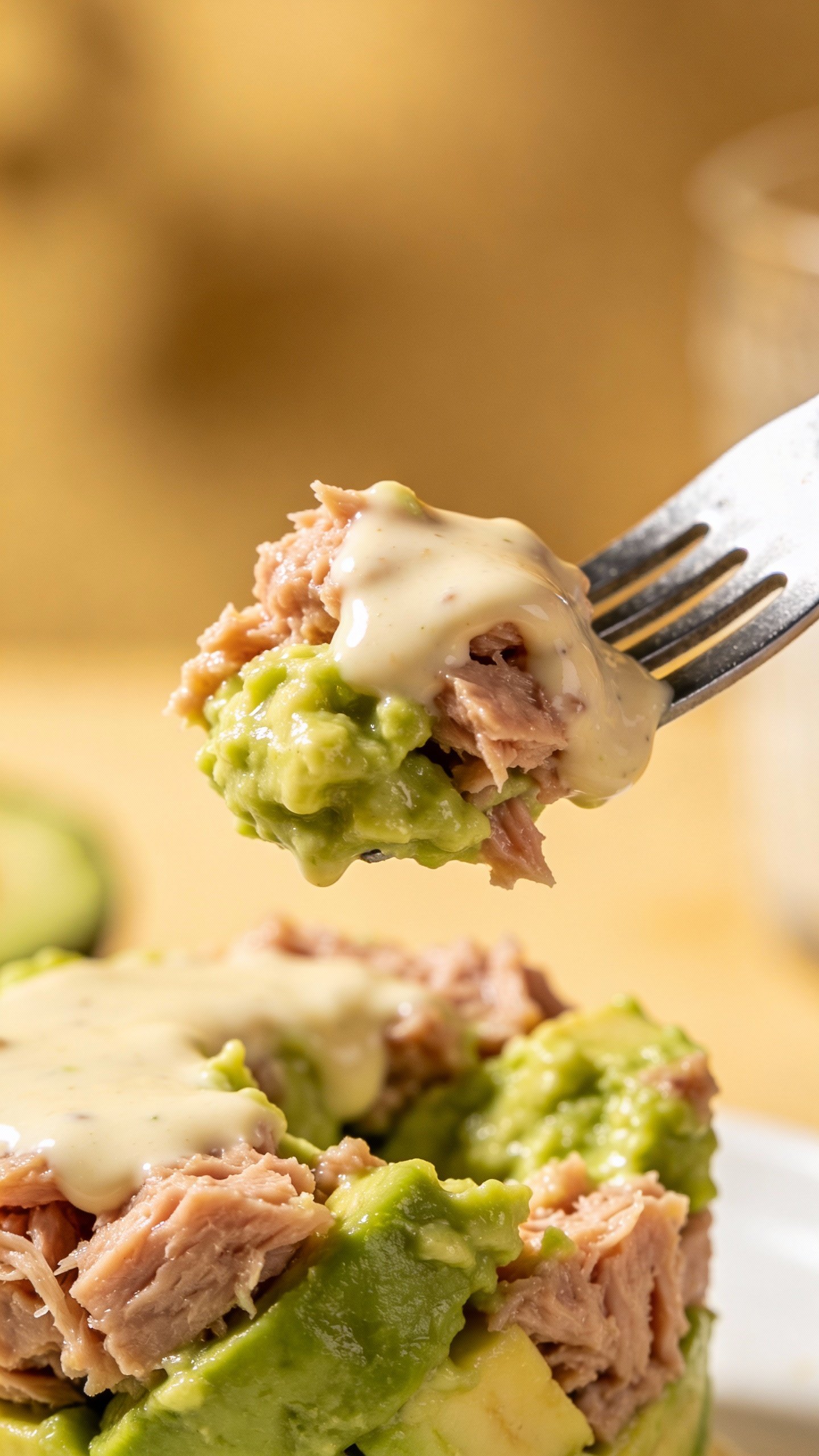 fork lifting creamy tuna avocado bite, shallow depth of field
