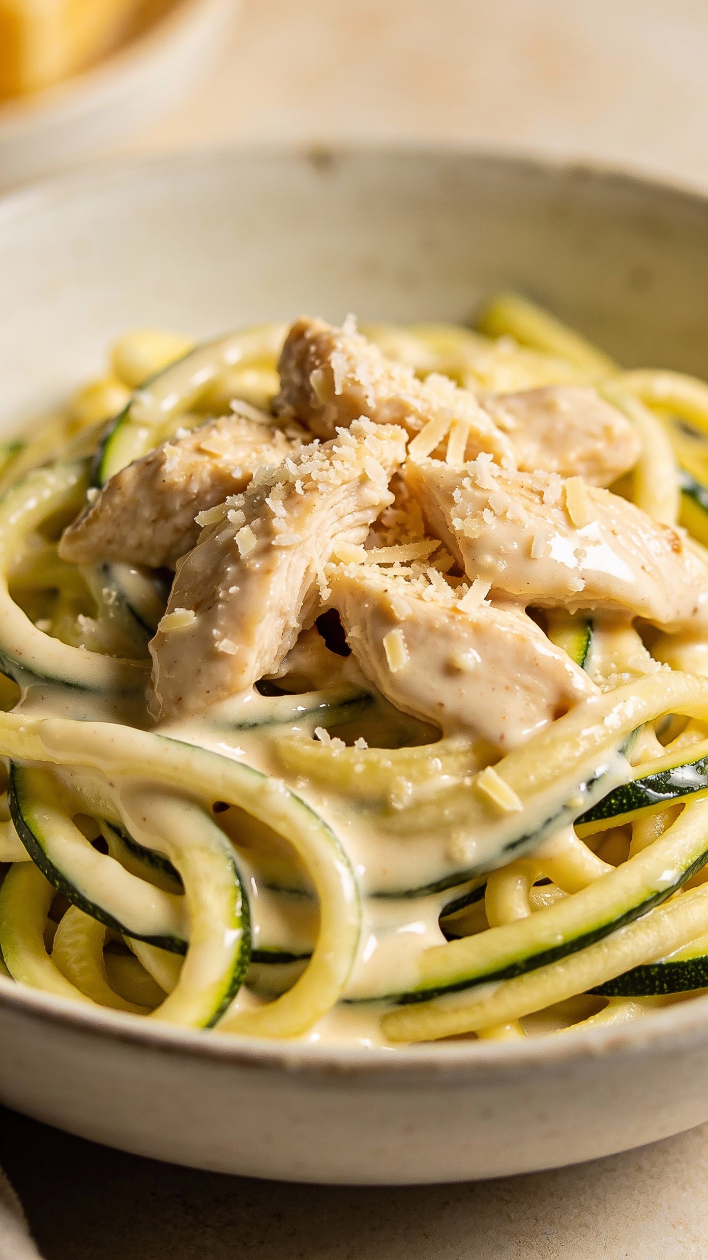 closeup bowl of chicken alfredo zoodles, creamy parmesan sauce
