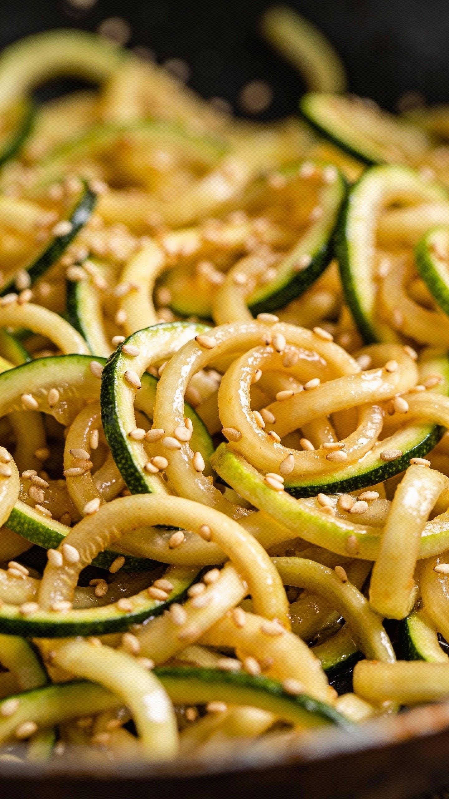 Single wok-tossed zucchini ribbons with sesame seeds, macro