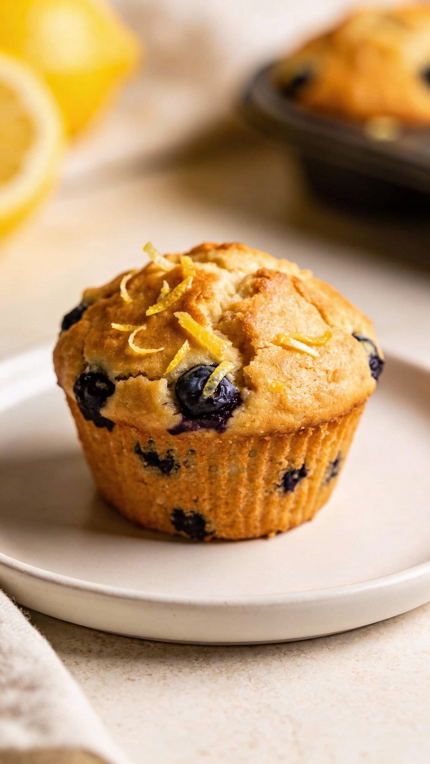 closeup lemon blueberry protein muffin on white ceramic plate