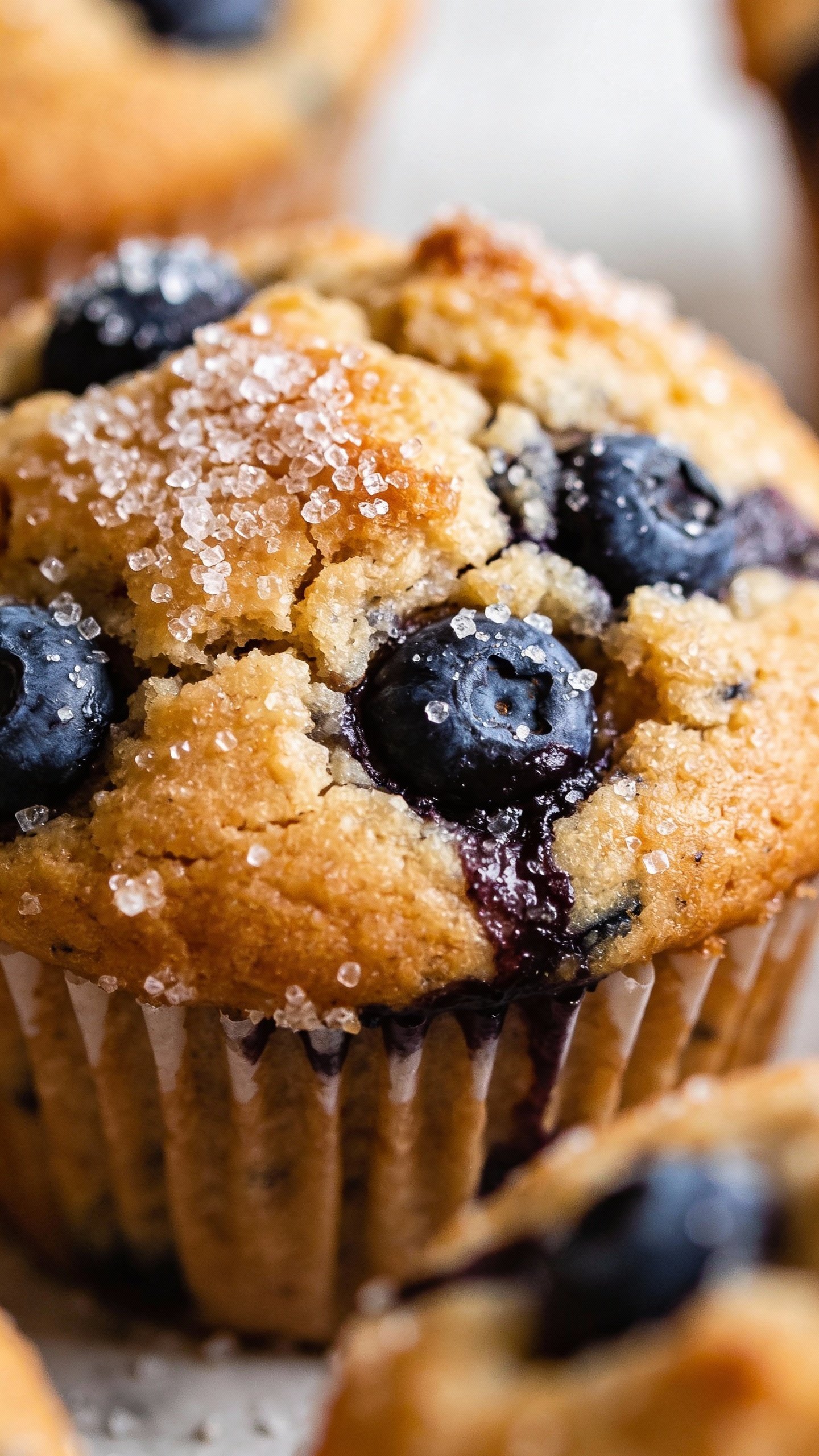 closeup gluten-free blueberry muffin with cracked sugar top