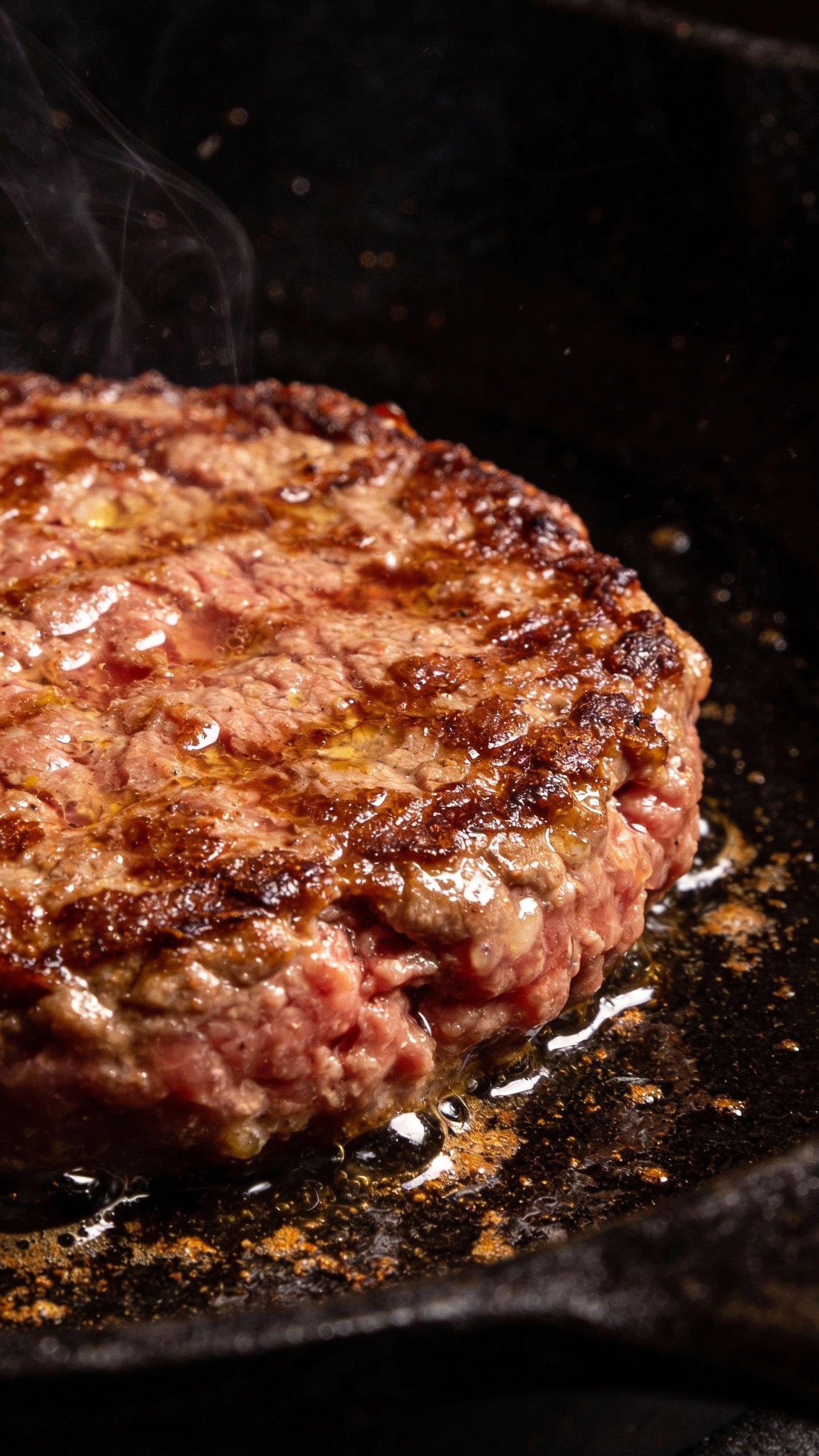 closeup 80/20 ground chuck patty sizzling on cast-iron