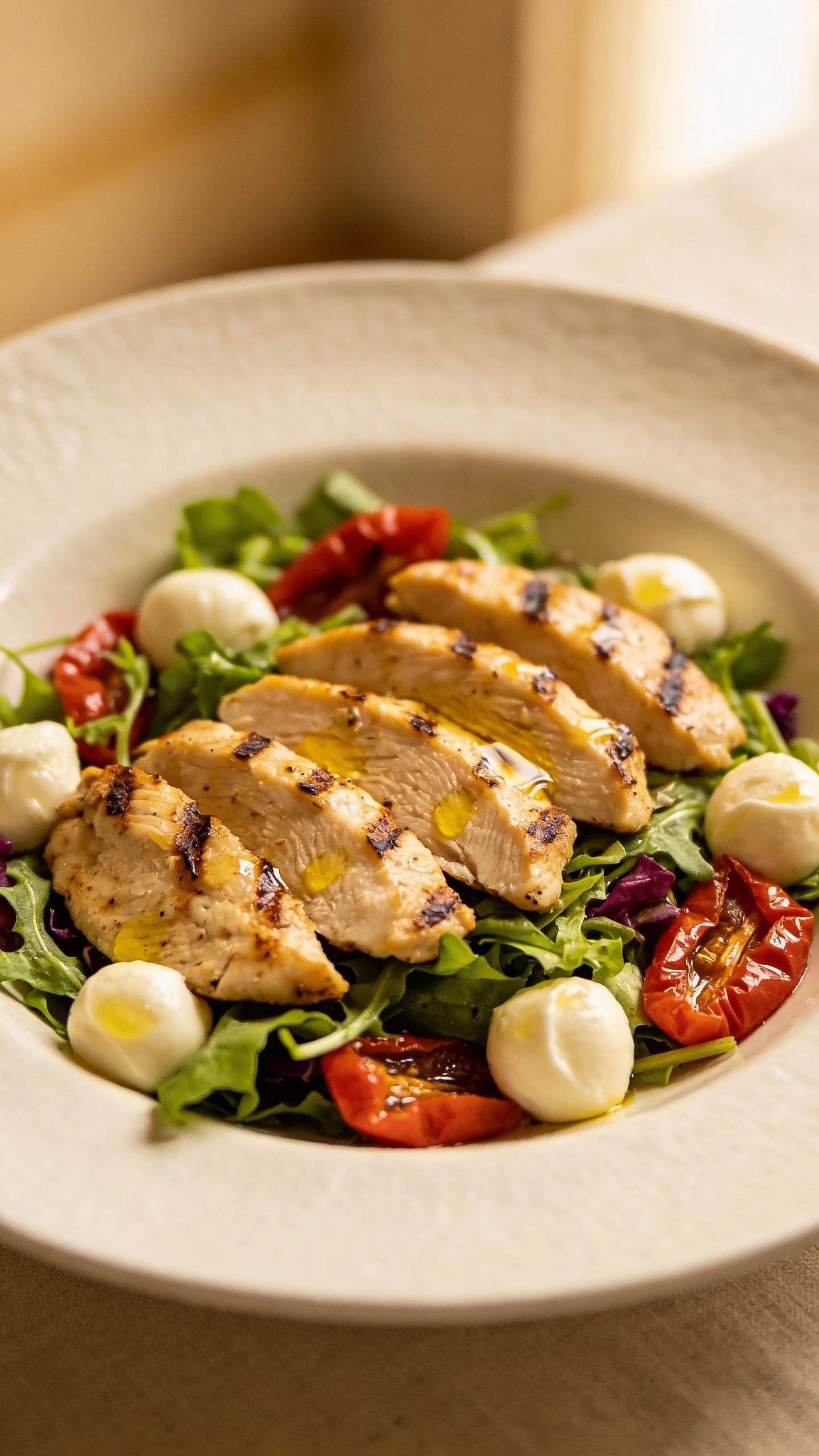 Single plate of grilled chicken antipasto salad, mozzarella pearls