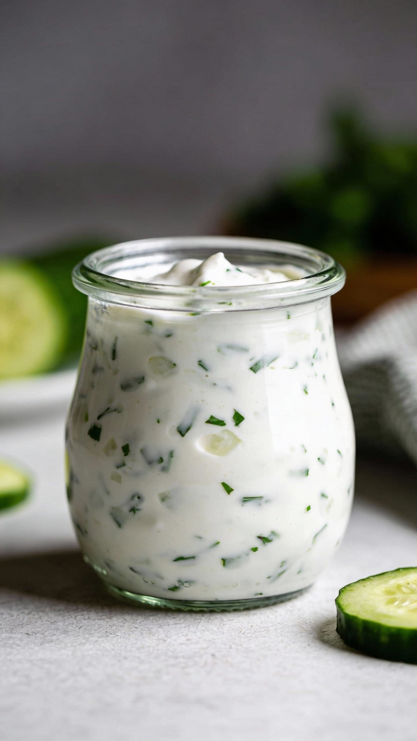 small glass jar of tzatziki sauce, studio lighting closeup