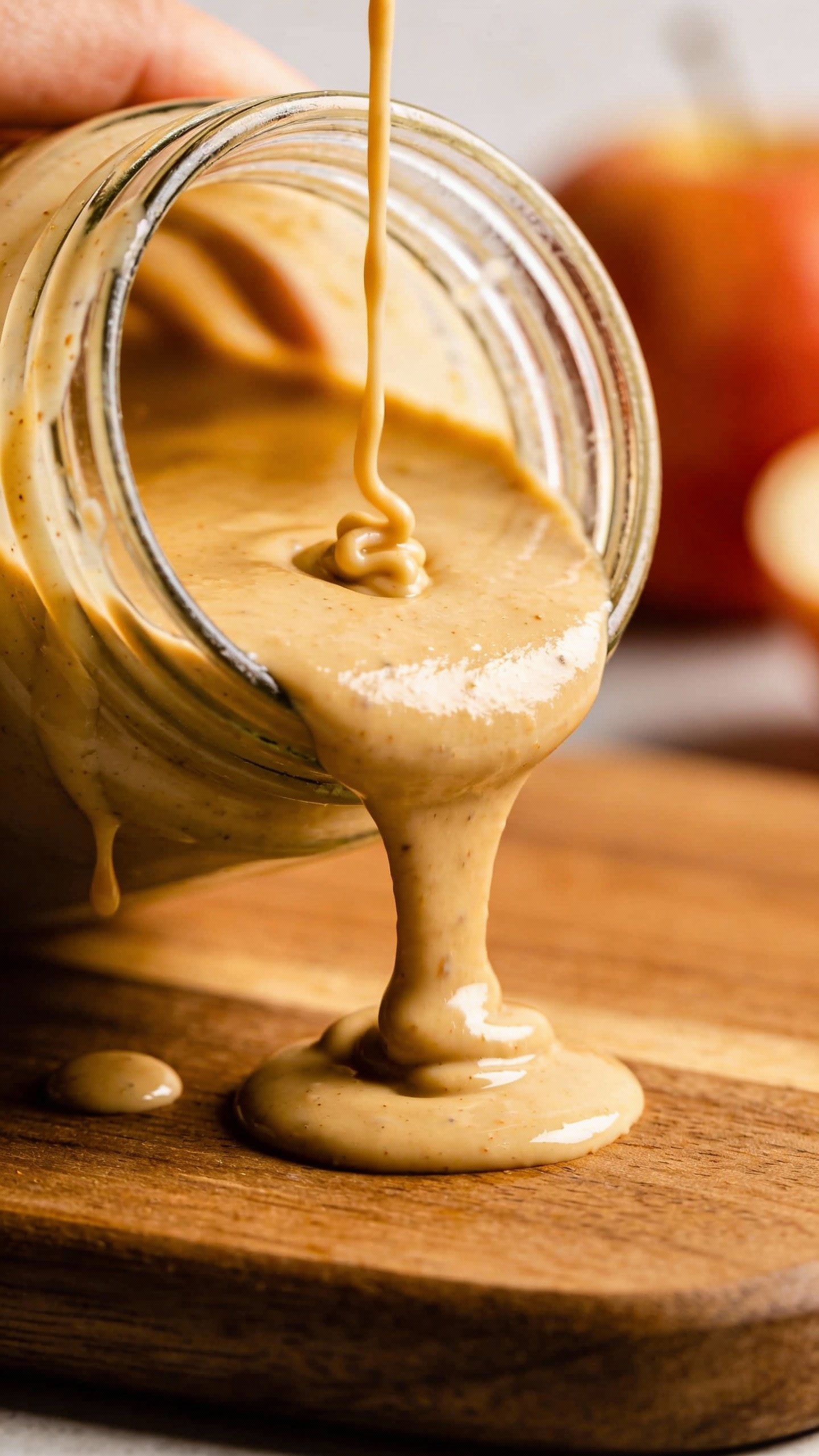 creamy tahini-apple cider dressing in glass jar, drips