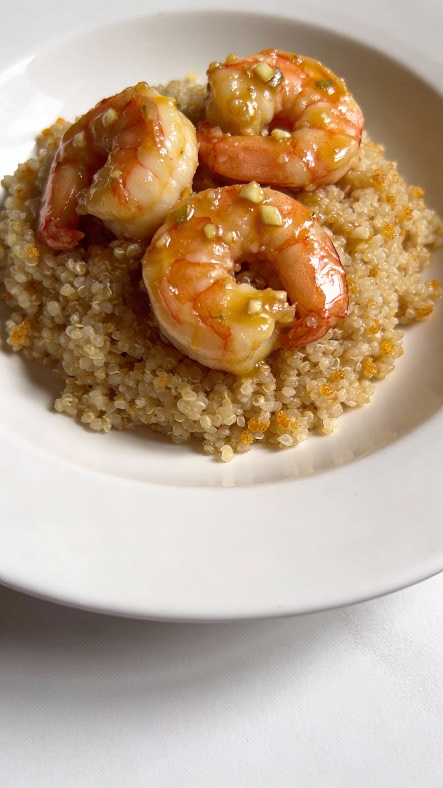 warm garlic butter shrimp over quinoa, minimalist white plate