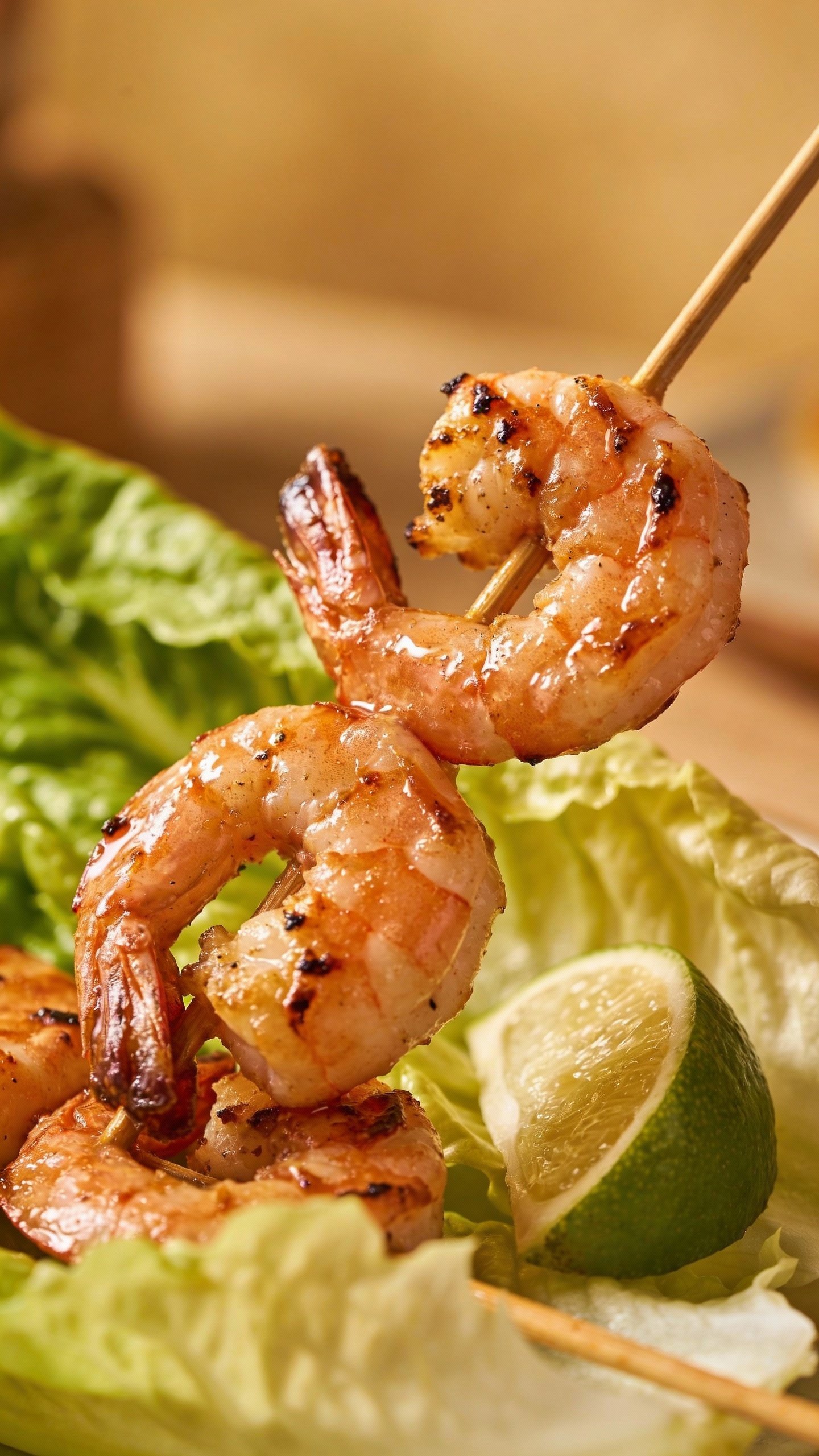 seared shrimp skewered over romaine with lime wedge