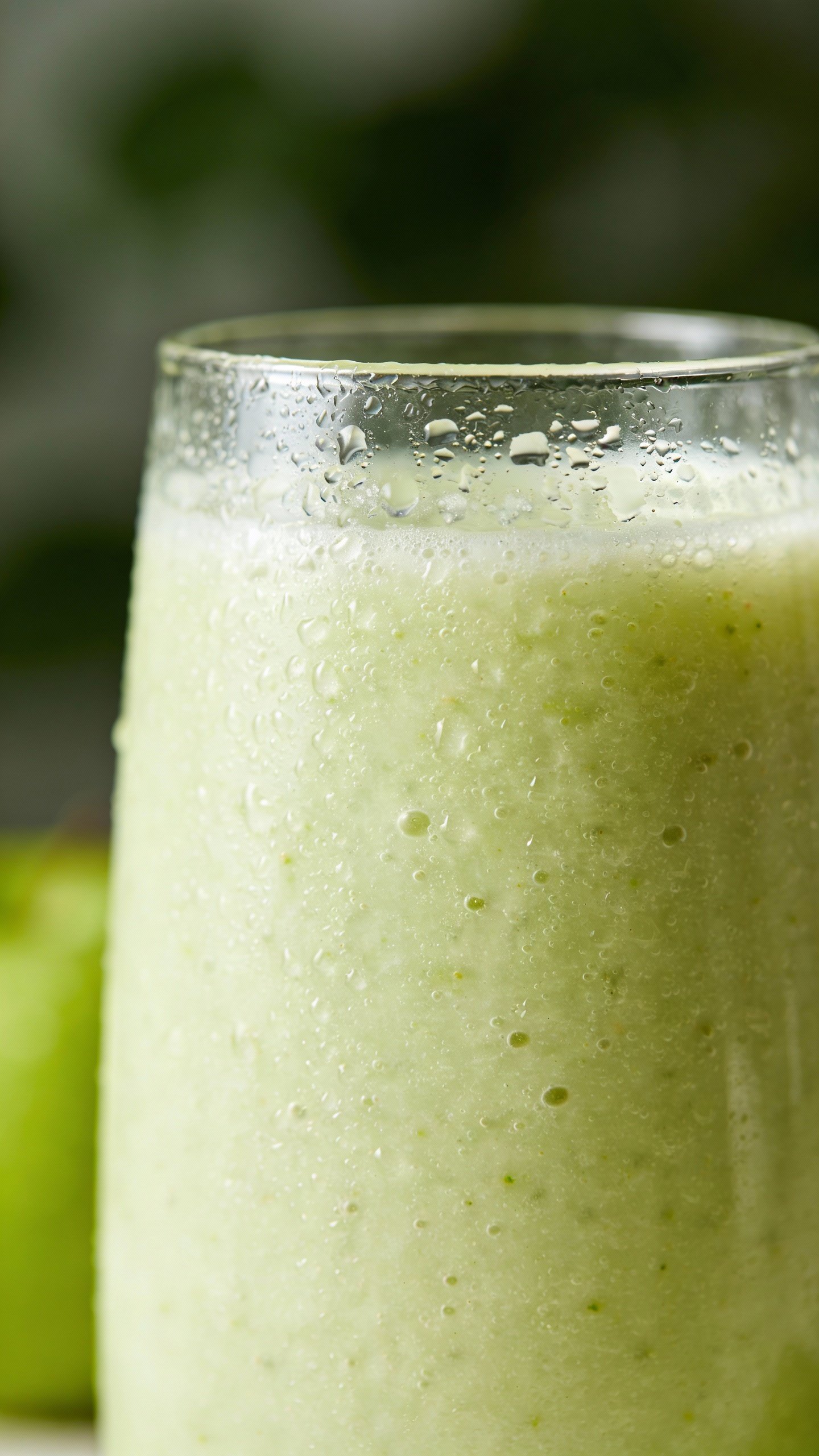 closeup of Granny Smith smoothie in clear glass, condensation