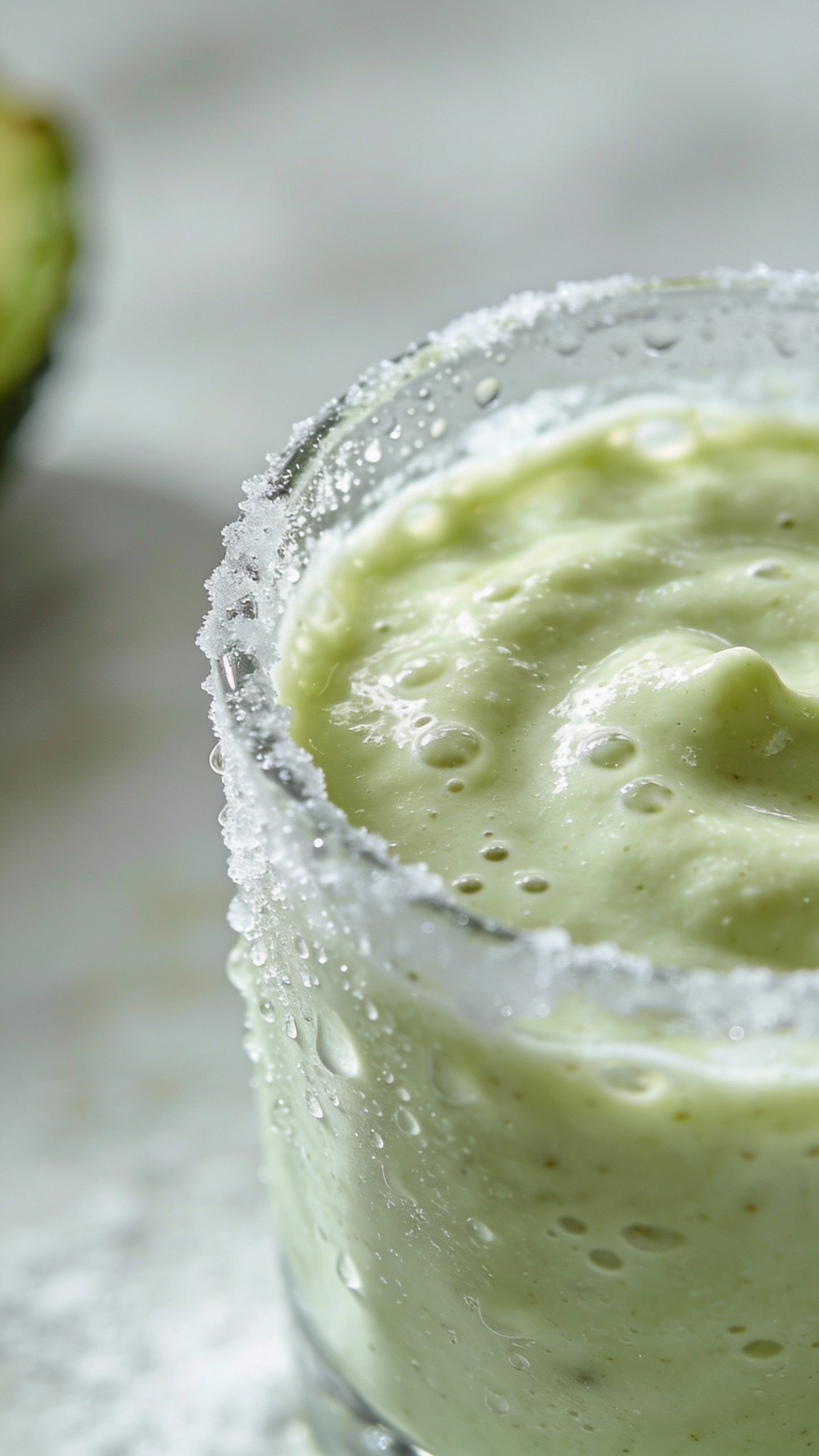 frosty avocado vanilla smoothie in clear glass, closeup